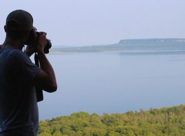 Screenshot of a climber taking a photo from the top of a cliff.